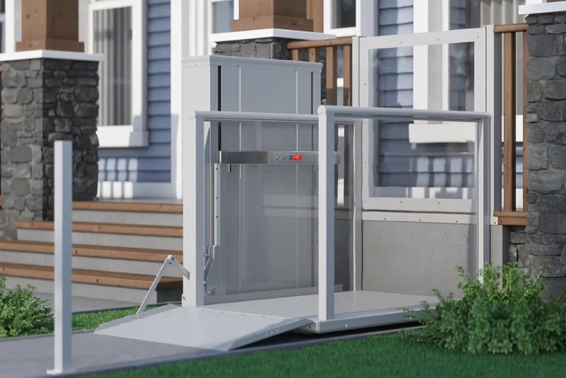 An AmeriGlide vertical platform lift installed beside the front steps of a home