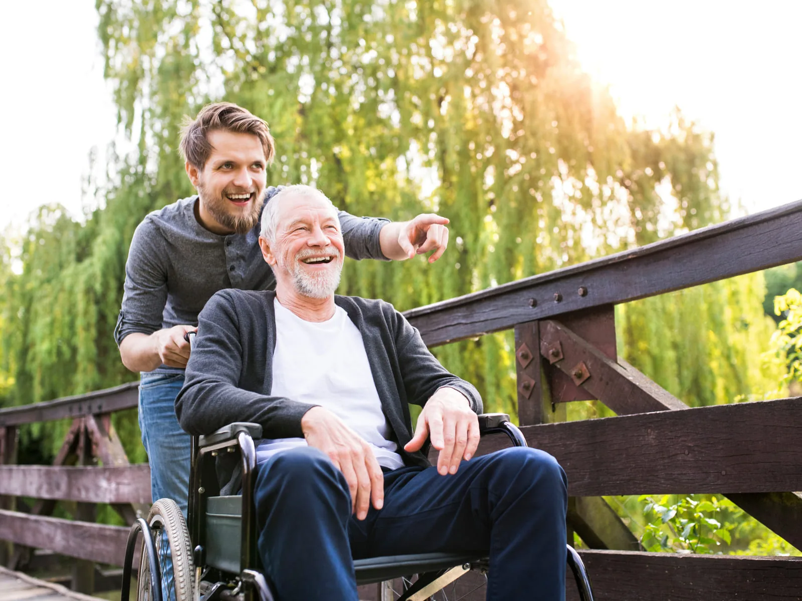 A caregiver out with a smiling senior in a wheelchair