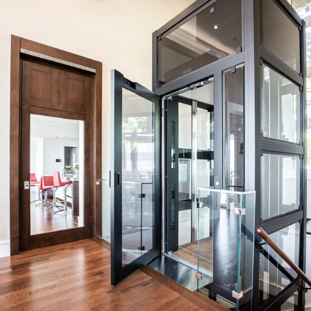 The RAM Crystal residential elevator with a glass hoistway in a home hallway