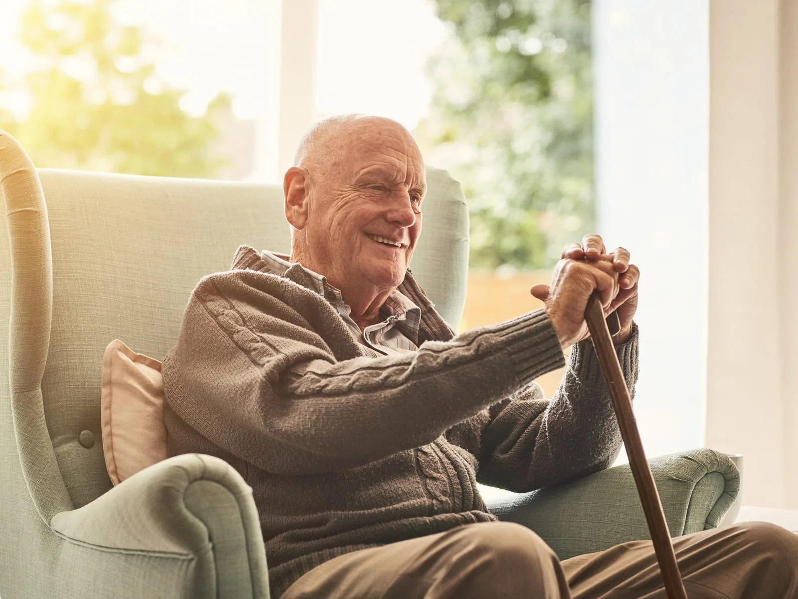 A senior relaxing at home, cane in hand